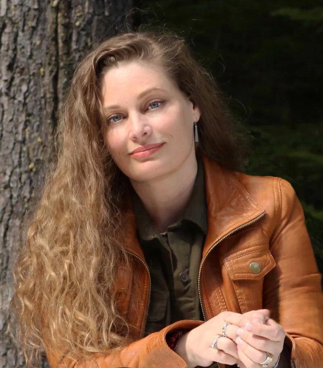 Sherry Hilliard, founder of Whistler Photo Safaris, seated beside a tree.